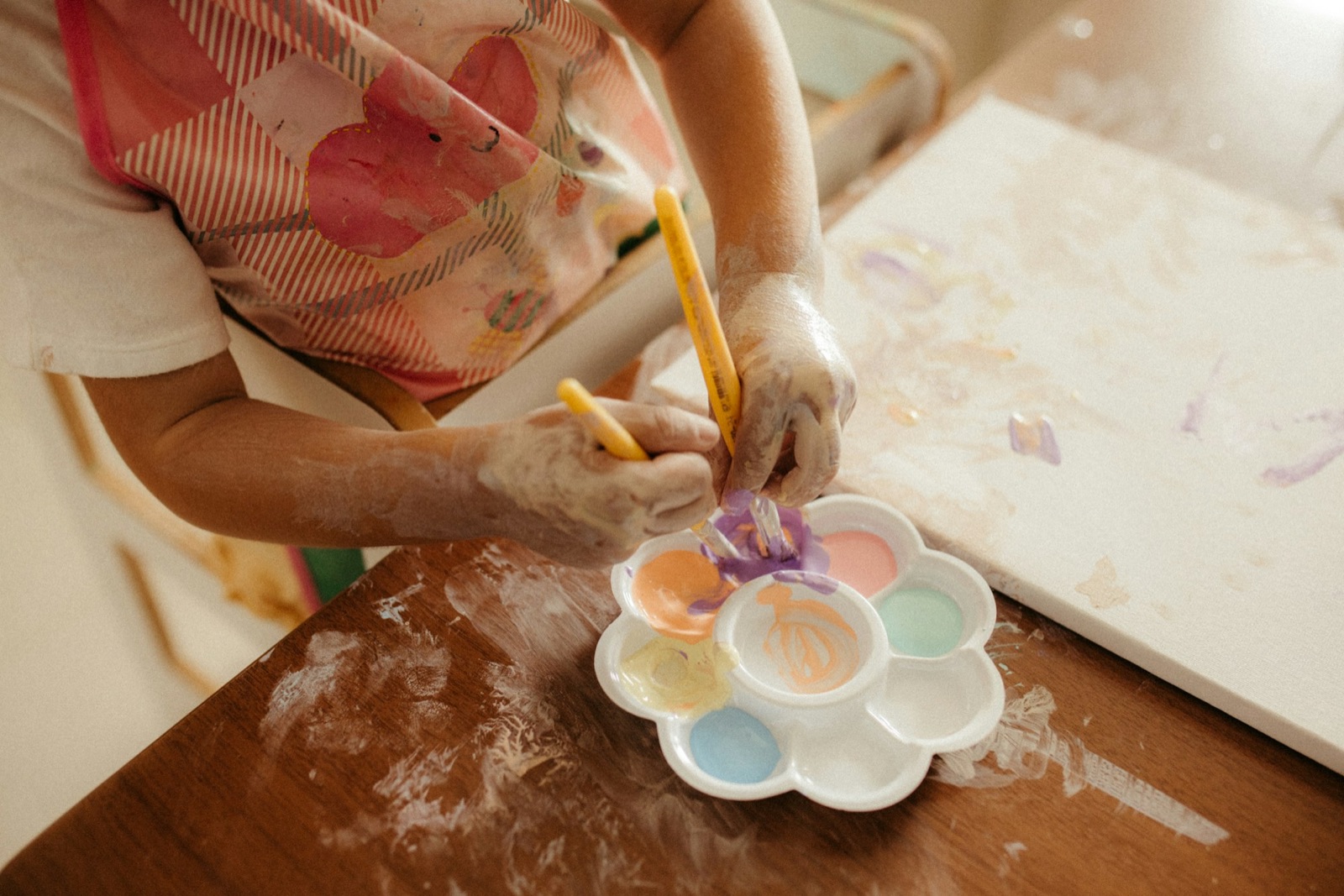 A child mixing watercolors on a palette