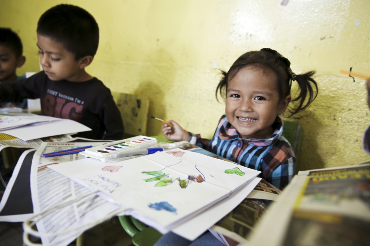 Children at a table, one smiling