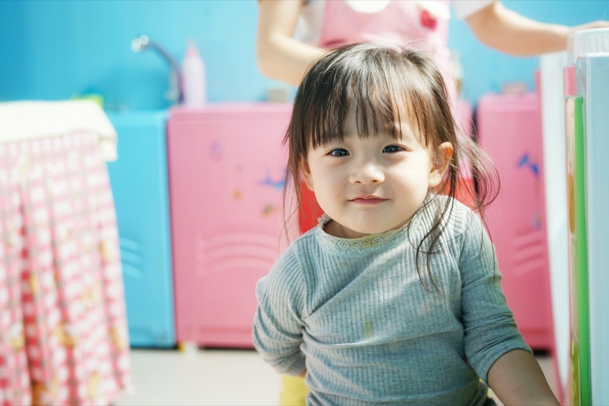 A toddler smiling in a bright room