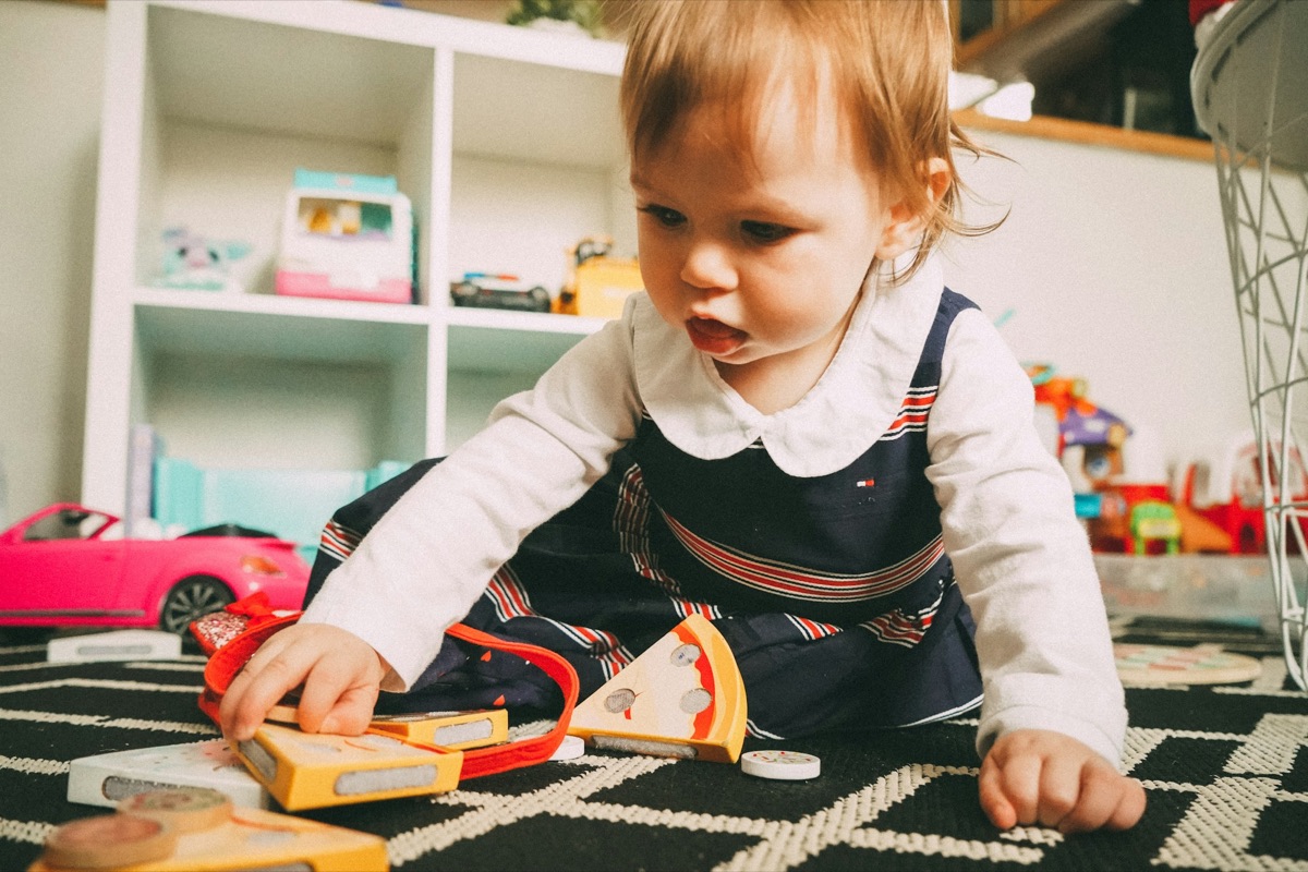 A toddler playing on the floor with a toy